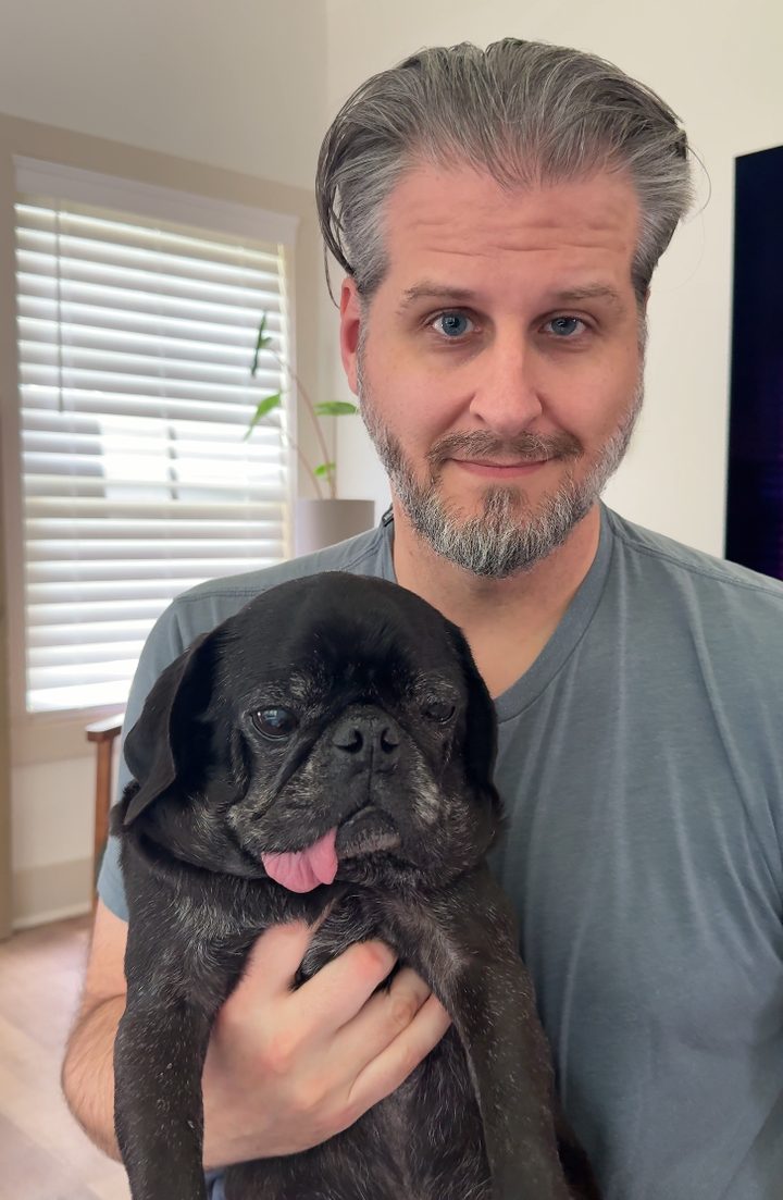 Adam Duke holding his pug Chester